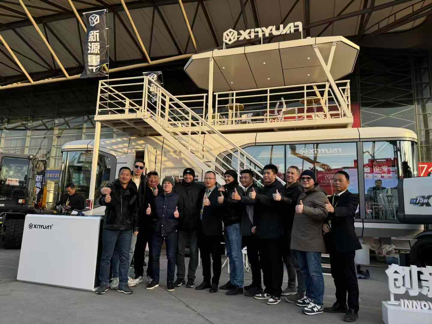 Колесный экскаватор xinyuan на выставке bauma время друзья из разных стран групповое фото